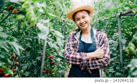 Portrait of a farm owner with crossed arms amid ripe green tomatoes Portrait of a farm owner with crossed arms amid ripe green tomatoes 143264118