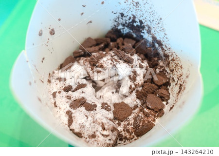 砕いたチョコレートクッキーをたっぷり混ぜたカップアイスのクローズアップ 砕いたチョコレートクッキーをたっぷり混ぜたカップアイスのクローズアップ 143264210