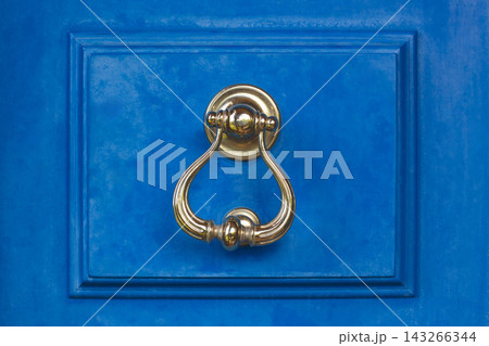 Vintage brass door knocker on a vibrant blue wooden door in Bodrum Vintage brass door knocker on a vibrant blue wooden door in Bodrum 143266344