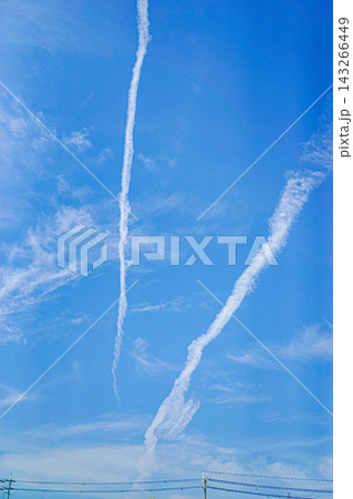 青空を縦に伸びる二本の白い飛行機雲 143266449