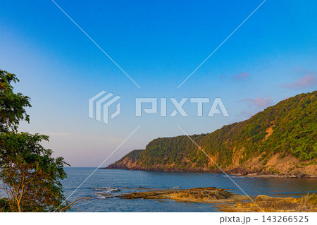 青い海に面した岩礁と緑の断崖が続く海岸風景 143266525