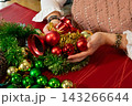 Woman Creating a Festive Christmas Ornament Centerpiece 143266644