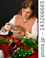 Hands Crafting Christmas Holiday Decoration with Ornaments 143266665