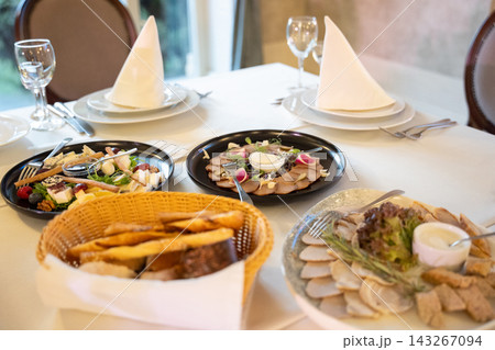 Assorted gourmet appetizers and bread basket served on a restaurant table Assorted gourmet appetizers and bread basket served on a restaurant table 143267094