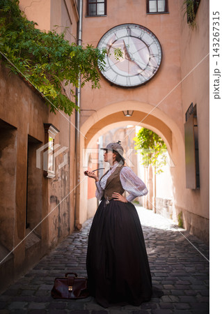 beautiful woman scientist in retro style smokes a pipe on the street of the old city 143267315