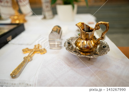 Golden liturgical set with a cross, pitcher, and ornate tray Golden liturgical set with a cross, pitcher, and ornate tray 143267990