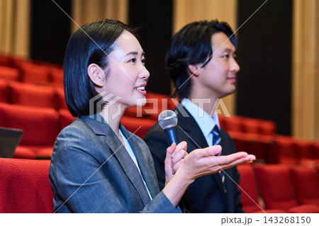 ビジネスイベントでノートパソコンを開き意見を述べるスーツ姿の女性 ビジネスイベントでノートパソコンを開き意見を述べるスーツ姿の女性 143268150