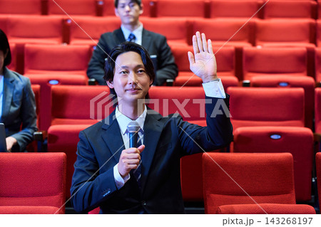 講演会の質疑応答でマイクを持ち発言する参加者の男性 講演会の質疑応答でマイクを持ち発言する参加者の男性 143268197
