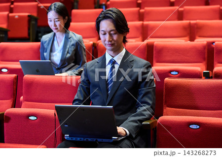 講演会の客席で積極的に質問をするスーツ姿の男性と参加者 講演会の客席で積極的に質問をするスーツ姿の男性と参加者 143268273