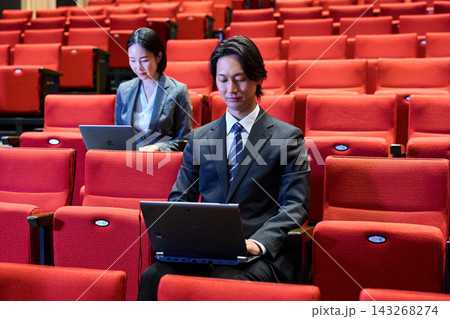 講演会の客席で積極的に質問をするスーツ姿の男性と参加者 講演会の客席で積極的に質問をするスーツ姿の男性と参加者 143268274