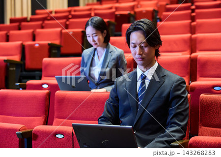 講演会の客席で積極的に質問をするスーツ姿の男性と参加者 講演会の客席で積極的に質問をするスーツ姿の男性と参加者 143268283