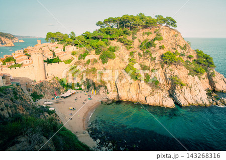 Vila Vella fortress above rocky cove in Tossa de Mar on Costa Brava. Mediterranean destination for coastal hiking beach vacations and seaside tourism Vila Vella fortress above rocky cove in Tossa de Mar on Costa Brava. Mediterranean destination for coastal hiking beach vacations and seaside tourism 143268316