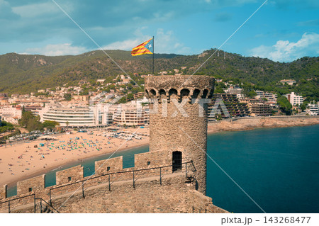 Medieval watchtower and Vila Vella fortress above Tossa de Mar beach in Spain. Iconic Costa Brava landmark for sightseeing Mediterranean vacations and cultural travel 143268477