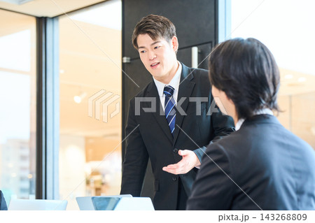 明るいオフィスやイベント会場で会議をするビジネスパーソン 明るいオフィスやイベント会場で会議をするビジネスパーソン 143268809