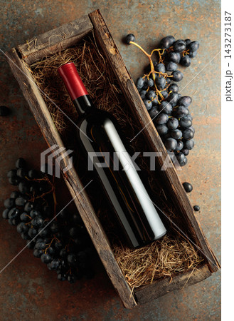 Bottle of red wine in an antique wooden box. 143273187
