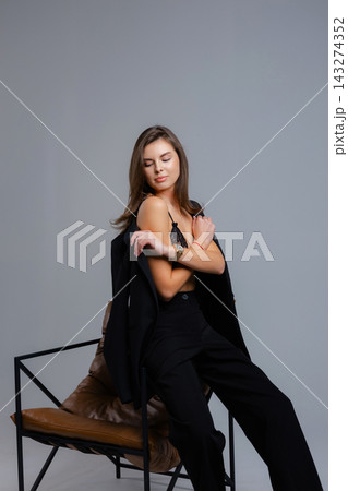 Businesswoman removing jacket sitting on chair with closed eyes 143274352