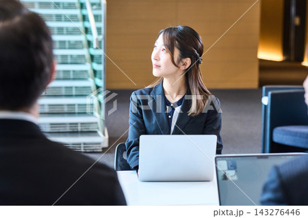 オフィスでノートパソコンを開き真剣に説明を聞く若手女性社員 オフィスでノートパソコンを開き真剣に説明を聞く若手女性社員 143276446