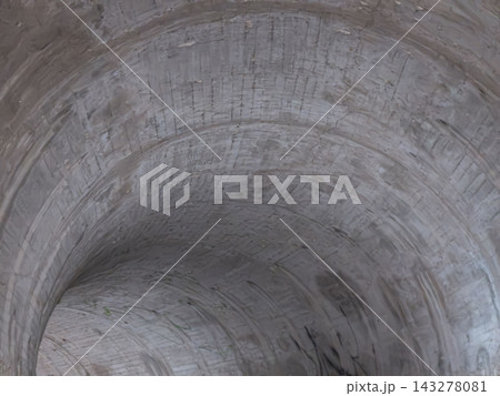 Low angle view of textured concrete interior of a bridge archway or tunnel Low angle view of textured concrete interior of a bridge archway or tunnel 143278081