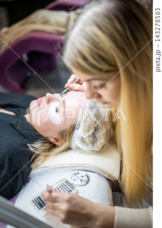 Eyelash extension procedure in beauty salon. Lashes close up. Concept spa lash. Eyelash extension procedure in beauty salon. Lashes close up. Concept spa lash. 143278583