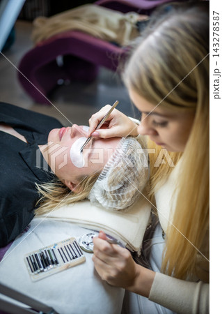 Eyelash extension procedure in beauty salon. Lashes close up. Concept spa lash.  143278587