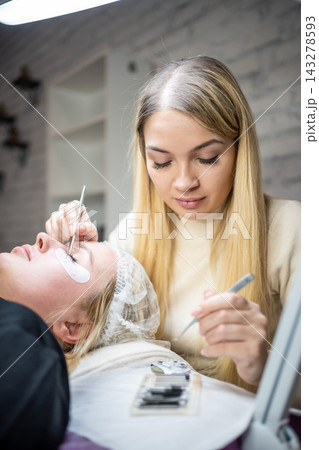 Eyelash extension procedure in beauty salon. Lashes close up. Concept spa lash. Eyelash extension procedure in beauty salon. Lashes close up. Concept spa lash. 143278593