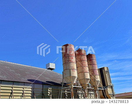 Rusty Silos On Steel Legs Under A Deep Blue Sky Rusty Silos On Steel Legs Under A Deep Blue Sky 143278813