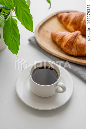 Cup of freshly espresso coffee and fresh croissants on a white background 143279321