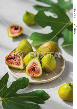 Fresh Ripe Figs with Green Leaves on Ceramic Plate Fresh Ripe Figs with Green Leaves on Ceramic Plate 143279330