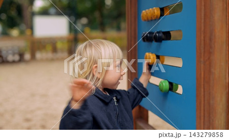 White blond toddler exploring sensory wall at playground White blond toddler exploring sensory wall at playground 143279858