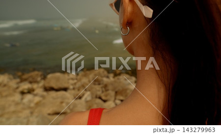 Summer accessory showcasing pearl earrings on rugged coastline backdrop Summer accessory showcasing pearl earrings on rugged coastline backdrop 143279963