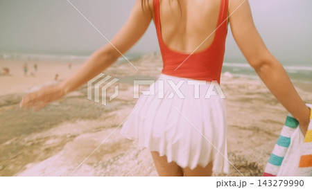 Energetic woman in swimsuit spinning near sunlit stones Energetic woman in swimsuit spinning near sunlit stones 143279990