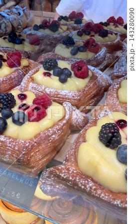 Colorful assortment of berrytopped custard pastries in display case Colorful assortment of berrytopped custard pastries in display case 143280090