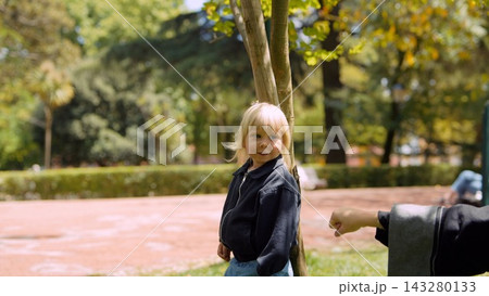 Little boy stands near bench quietly contemplating autumn scenery 143280133