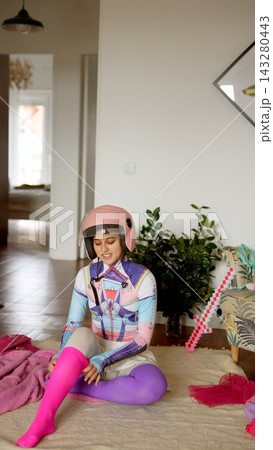 Young girl in colorful clothes gets ready for scooter ride at home Young girl in colorful clothes gets ready for scooter ride at home 143280443
