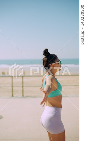 Female runner performing chest opener stretch before run Female runner performing chest opener stretch before run 143280500