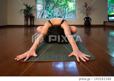 Woman practicing yoga doing child's pose Woman practicing yoga doing child's pose 143281388