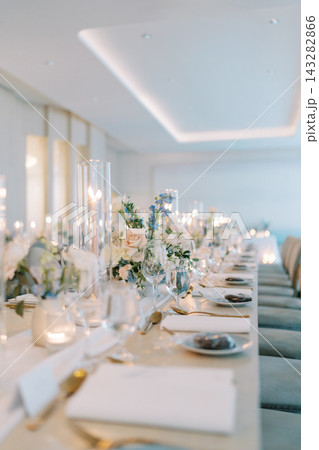 Luxury wedding luncheon table styled with vibrant blossoms and atmospheric lighting ambiance 143282866