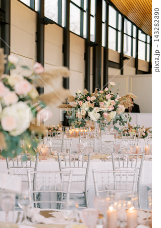 Elegant wedding reception with floral centerpieces and candles Elegant wedding reception with floral centerpieces and candles 143282890