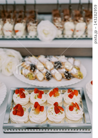 Stylish pastry arrangement with treats. Refined assortment of confections on glass trays 143282959