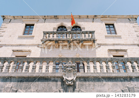 Historic Mediterranean style building with detailed balustrade and flag Historic Mediterranean style building with detailed balustrade and flag 143283179