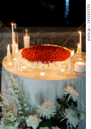 Romantic candle display. Heartshaped petals and soft candlelight setting Romantic candle display. Heartshaped petals and soft candlelight setting 143283339