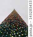 Christmas Tree with Colorful Ornaments and Lights Viewed from Below Against Overcast Sky 143283433