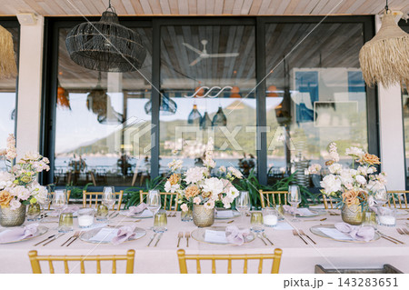 Refined gold chairs complement beautiful lakeside dining environment with decor Refined gold chairs complement beautiful lakeside dining environment with decor 143283651