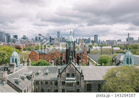 Trinity College Chapel with Toronto skyline and clouds 143284107