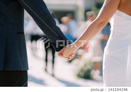 Close Up of Bride and Groom Holding Hands at Wedding Ceremony 143284296