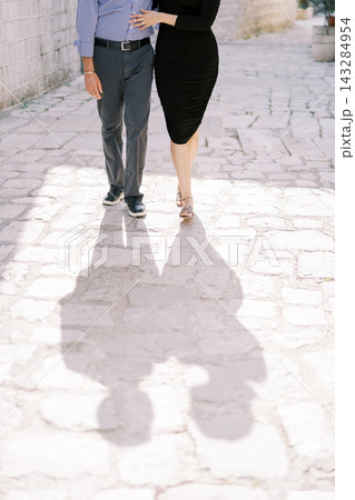Pair of lovers enjoying peaceful walk. Romantic pair of partners casually walking hand in hand through quiet park Pair of lovers enjoying peaceful walk. Romantic pair of partners casually walking hand in hand through quiet park 143284954
