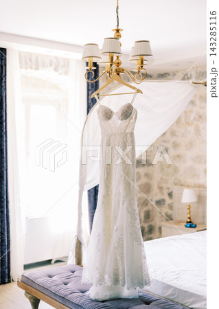 Serene bridal preparation environment featuring delicate dress and romantic lighting ambiance Serene bridal preparation environment featuring delicate dress and romantic lighting ambiance 143285116