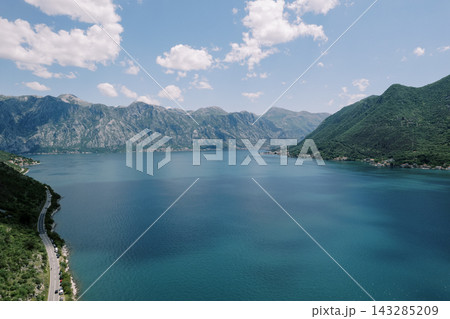 Wide azure bay with majestic mountains and tranquil cloud shadows fostering peaceful scenes Wide azure bay with majestic mountains and tranquil cloud shadows fostering peaceful scenes 143285209