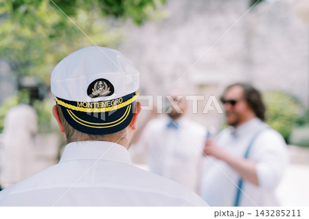 Seafarer watches guests interact. Officer observes socializing maritime visitors closely Seafarer watches guests interact. Officer observes socializing maritime visitors closely 143285211
