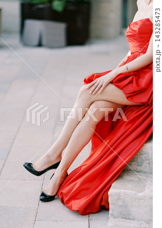 Two elegantly dressed women posed on stone pavement highlighting luxurious fashion details 143285473